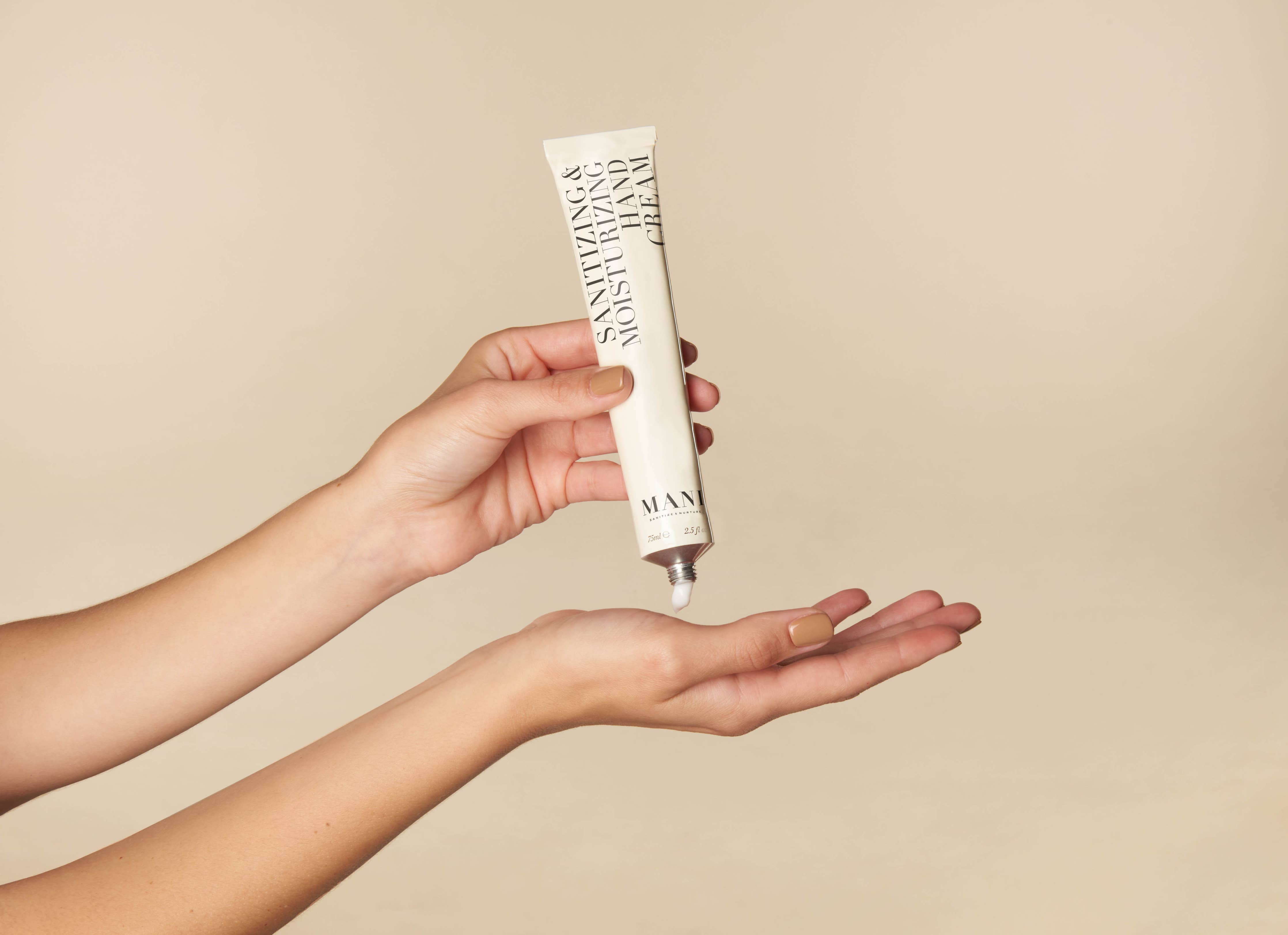 Hand holding a skincare product with a beige background