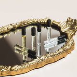Set of perfume samples on a decorative gold tray