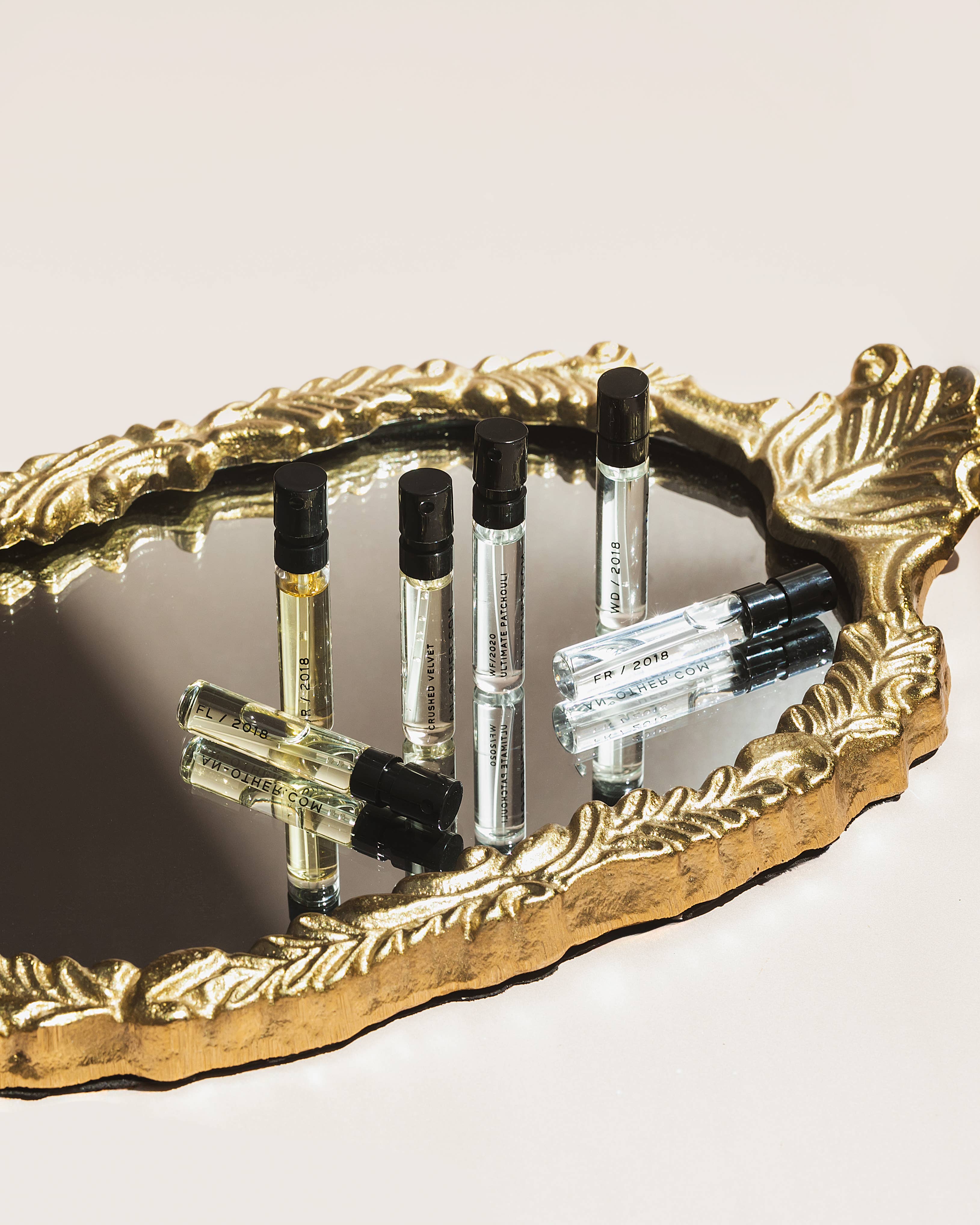 Set of perfume samples on a decorative gold tray