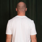 Person wearing a white t-shirt against a black background