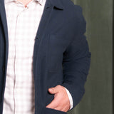 Navy blue jacket over a white shirt on a plain background