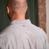 Back view of a person wearing a gray sweater with a blurred background
