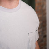 Close-up of a person wearing a light gray t-shirt with a blurred background