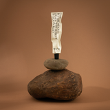 Tube of cream balanced on a rock against a brown background