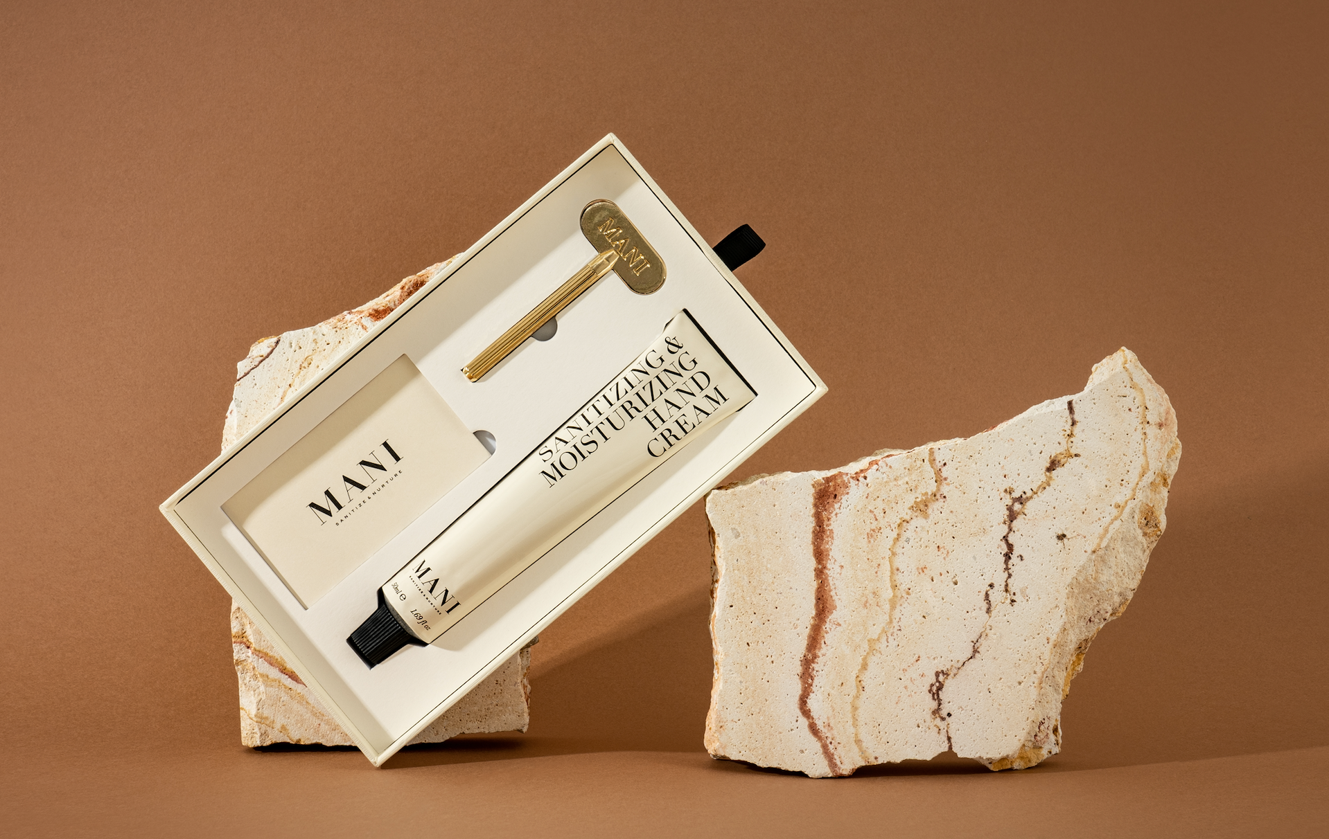 Mani hand cream in a box on a stone surface with a brown background