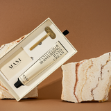 Mani hand cream in a box on a stone surface with a brown background