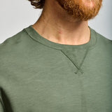 Man wearing a green shirt with a plain background