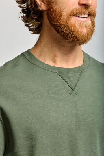 Man wearing a green shirt with a plain background