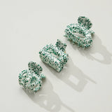 Green and white patterned hair accessories on a light background