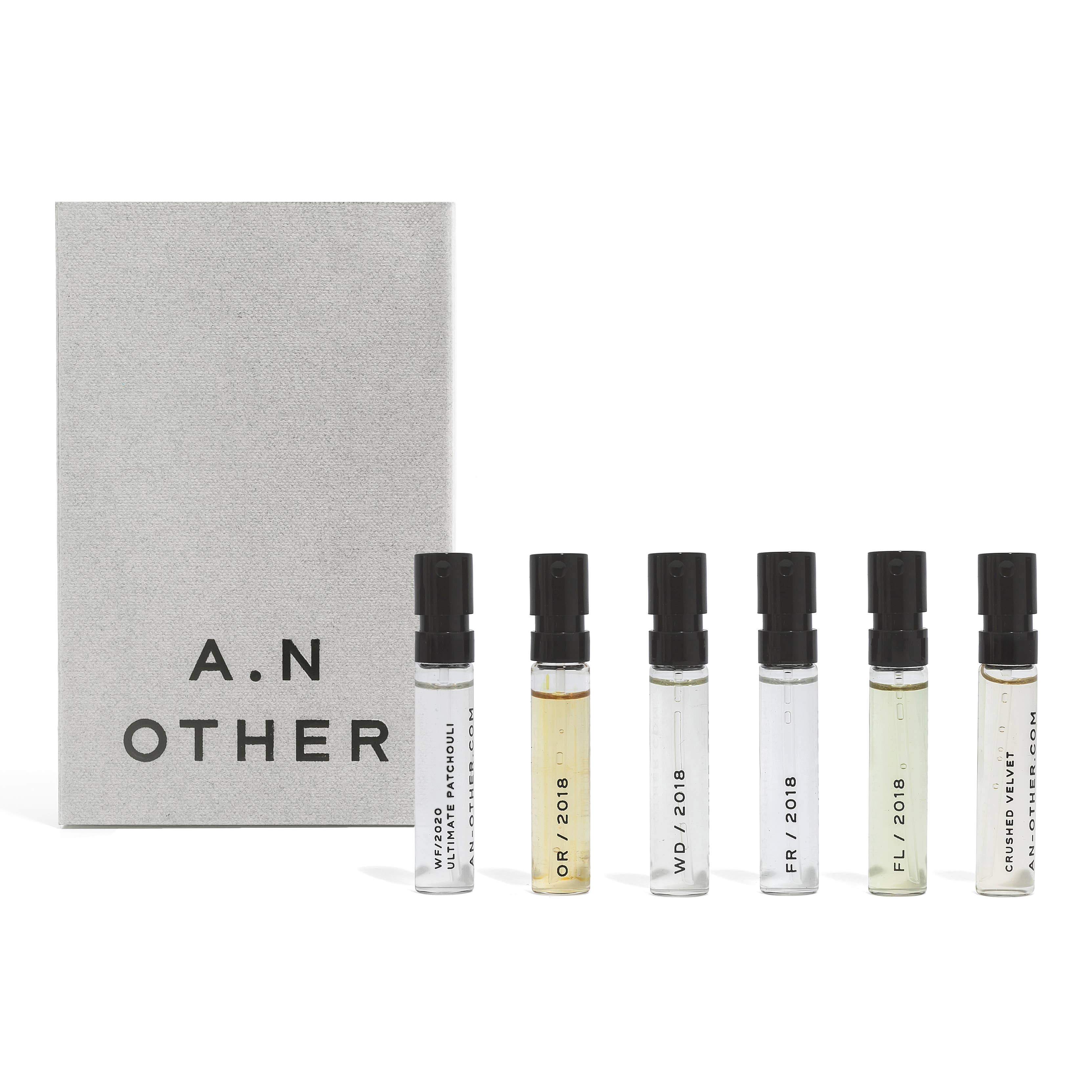 Set of six small perfume bottles with black caps and a branded box on a white background