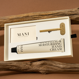 Mani sanitizing and moisturizing hand cream in a box with a gold applicator on a brown background.